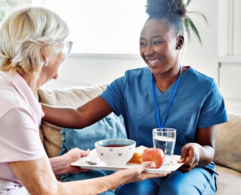Caregiver Assisting Alzheimers Patient With Their Food Tray
