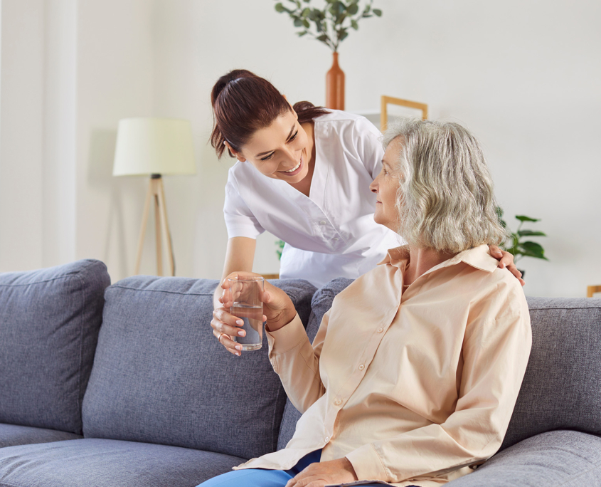 Caretaker Giving Water To Patient