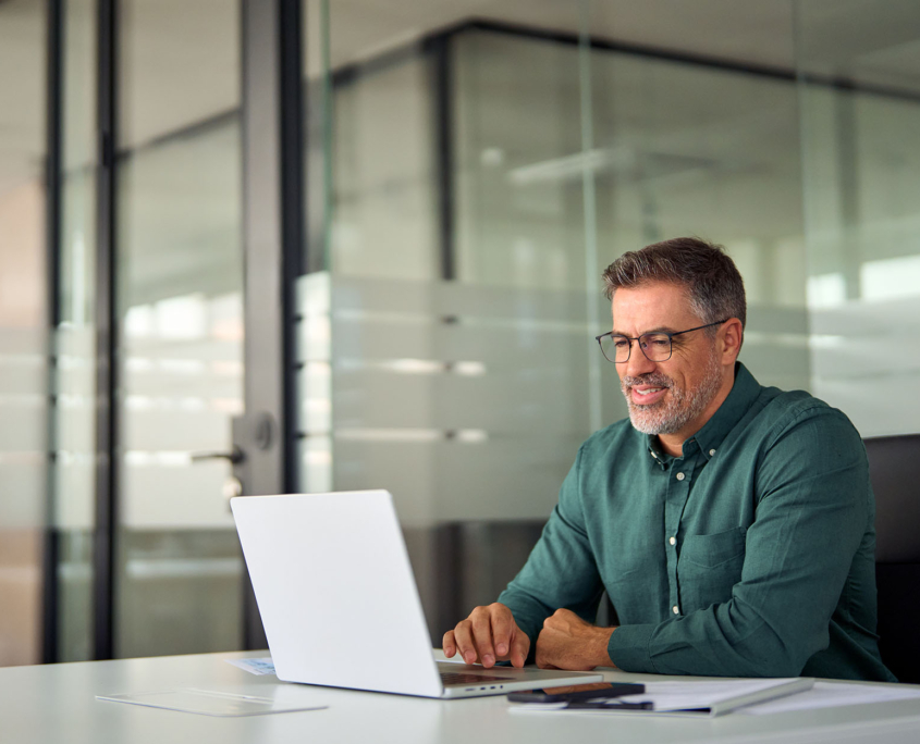 Side View Of Person Working On Laptop In Office